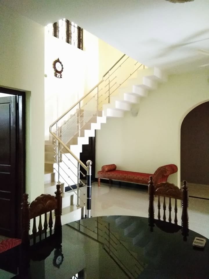 Bright completed living hall with open staircase and stainless steel railing