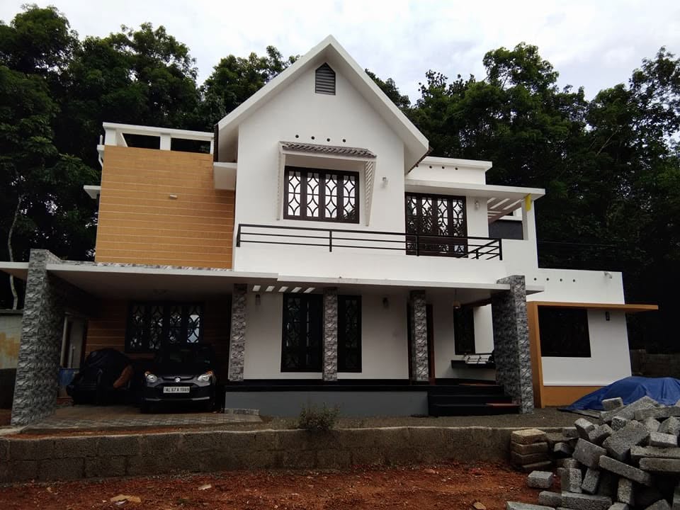 Front elevation of a completed white two-storey home with gabled roof and stone columns