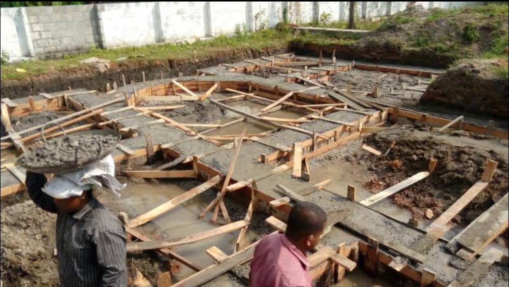 Construction team placing concrete within the foundation formwork