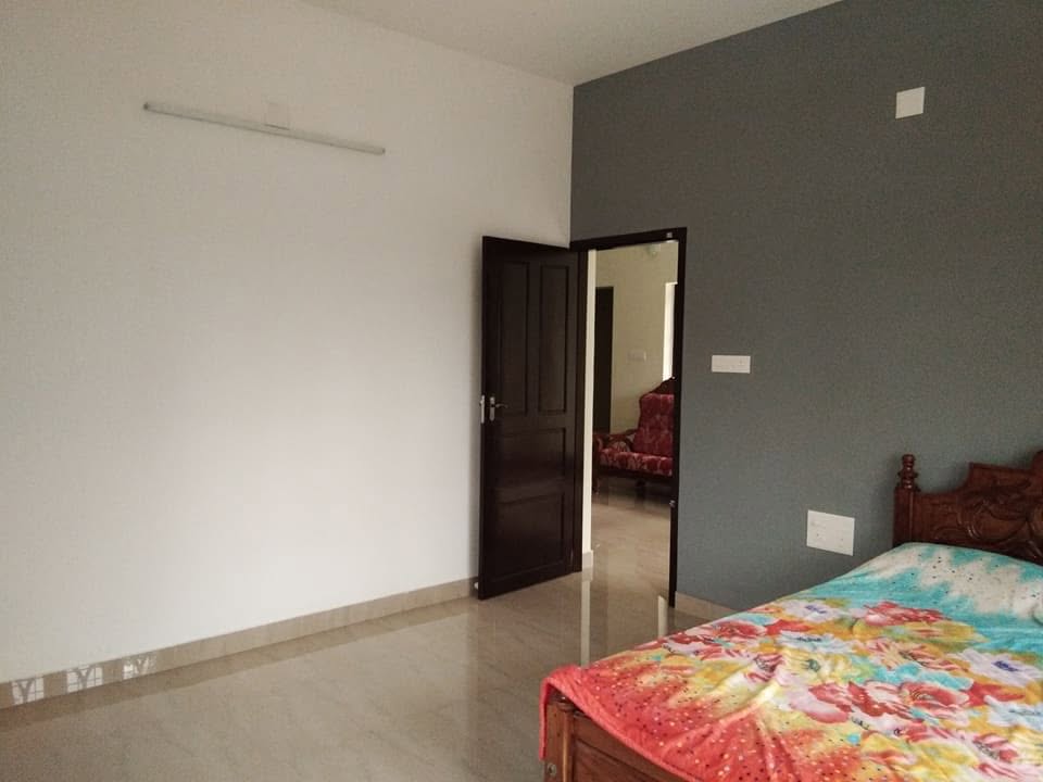 Completed bedroom with polished floor, dark accent wall and wooden door